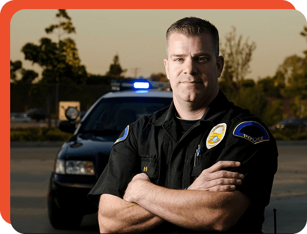 A police officer standing in front of his car.